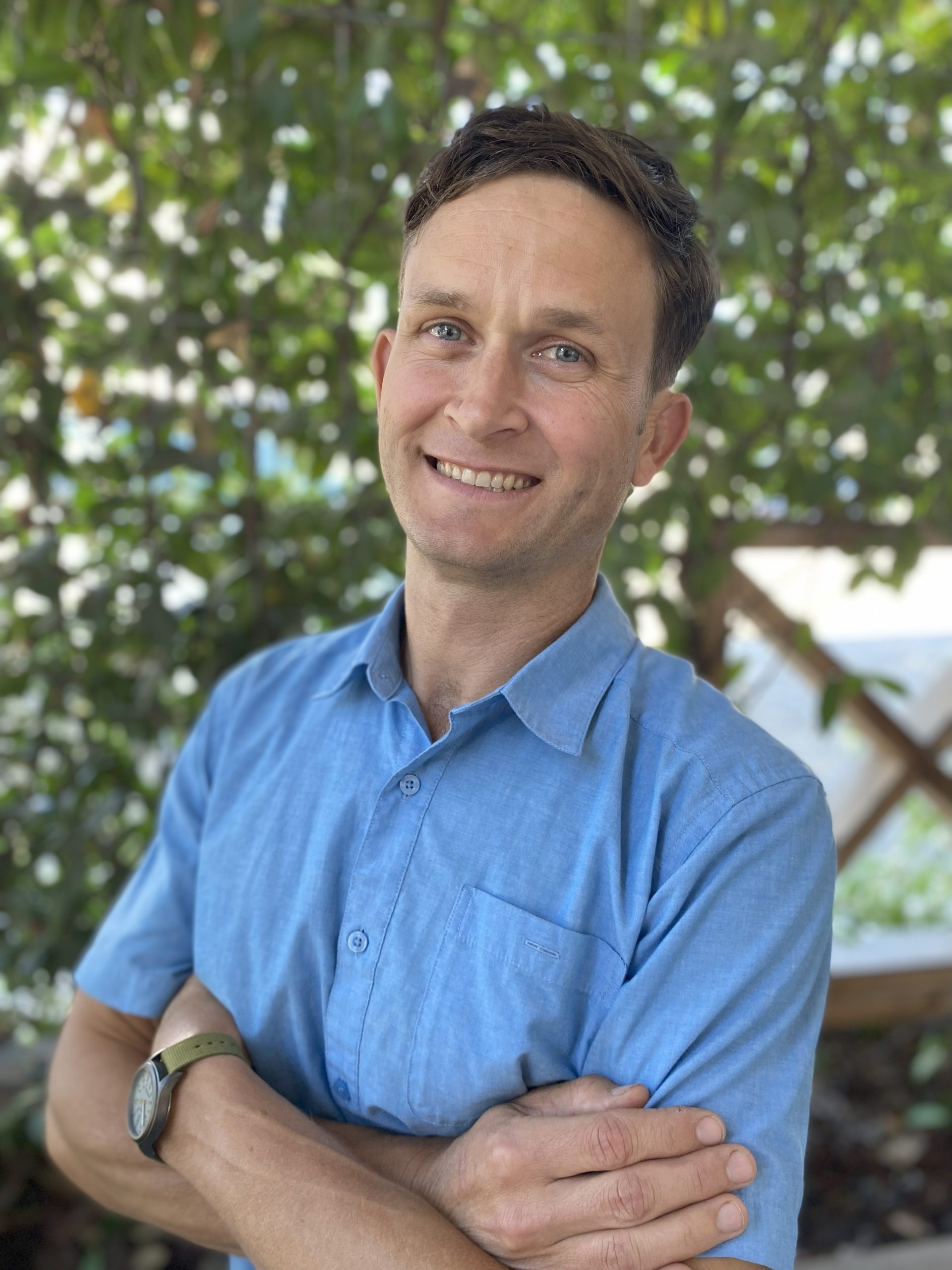 A portrait of Wally Daniel in a blue shirt